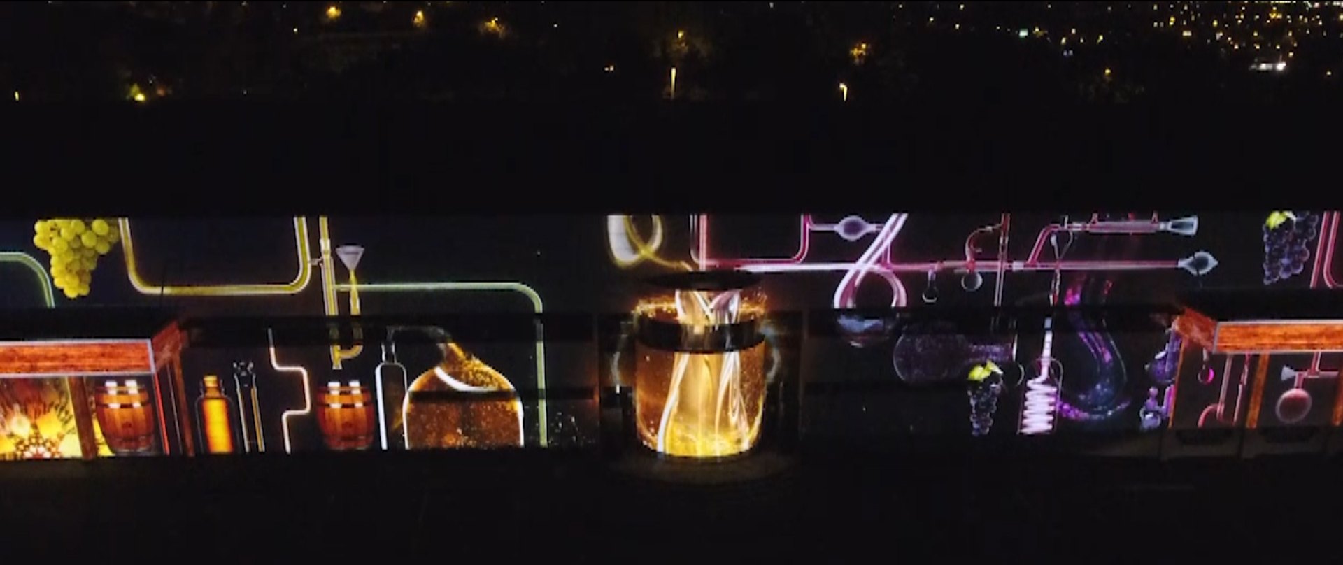 Projection mapping panorama: animated illustrated visuals mapped across a long wall at night